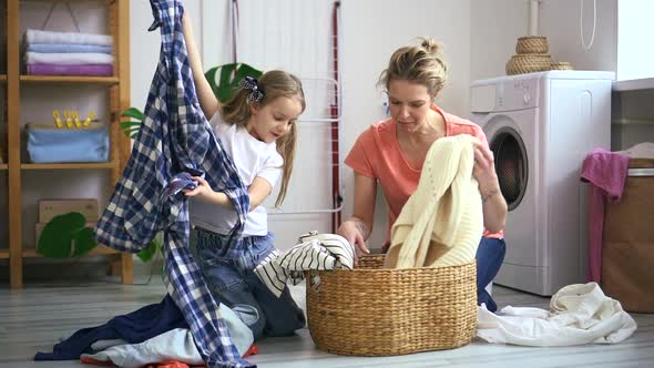 Mother and Daughter Sort Clean Clothing Together