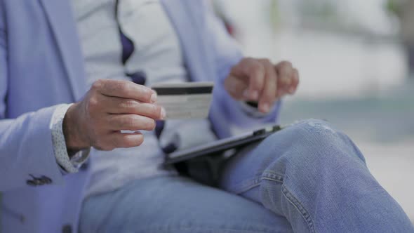 Man Using Tablet Pc and Holding Credit Card