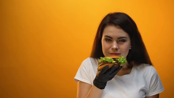 Girl Smelling Burger, Showing to Camera, Tasty Fast Food, Good Quality Product