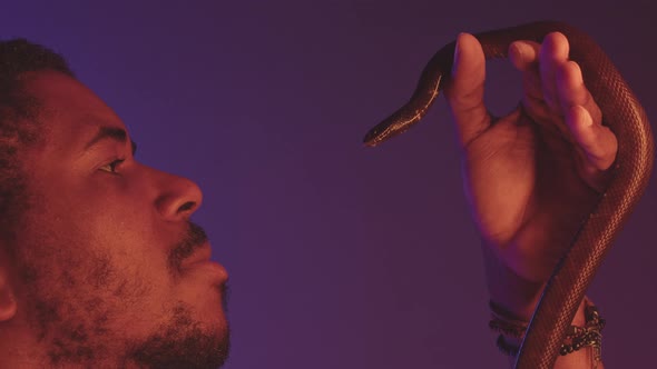 Black Man with Snake on Neon Purple Background