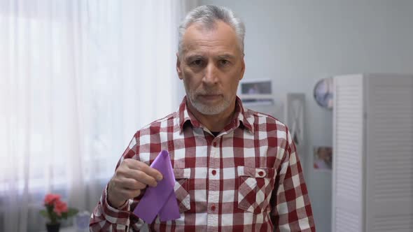 Senior Male Showing Purple Ribbon to Camera, Alzheimer Disease Awareness, Care