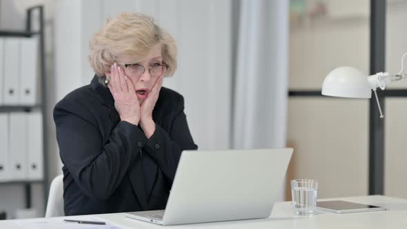 Old Businesswoman Reacting To Failure While Using Laptop at Work