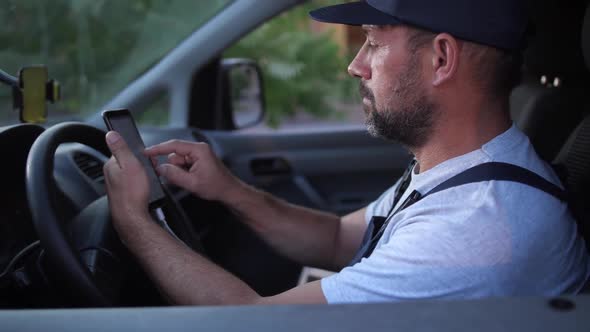 Bearded Delivery Man Choosing Route Before Driving