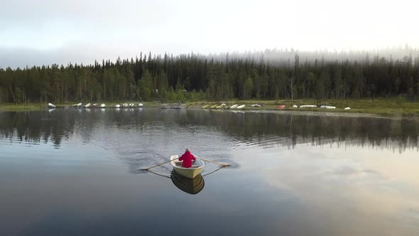 Small rowing boat on a foggy lake during a sunrise