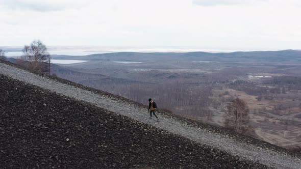 Aerial View of a Traveler Walking on a Mountain Against the Background of a Valley and Mountains