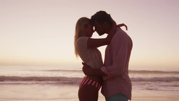 Caucasian couple enjoying time at the beach during the sunset