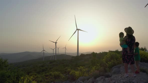 Aerial View Family Mom and Kids in the Mountains Near the Windmills at Sunset