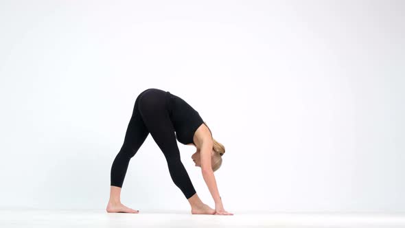 Young woman demonstrates a yoga pose on a white background.