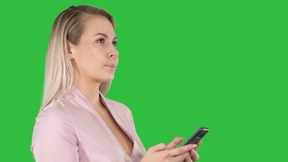 Portrait of cheerful young woman sending message on smartphone