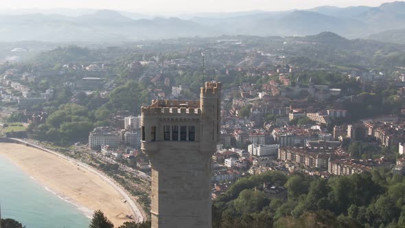 Castle tower with majestic view of San Sebastian in background, cinematic aerial view