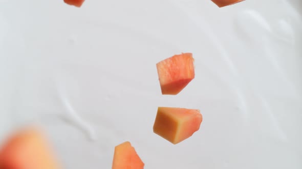 Tossing cut papaya in yoghurt. Overhead shot. Slow Motion.