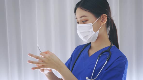 Close Up Female Asian Nurse Doctor Holding a Vaccine Injection Needle Ready for Vaccination at Work