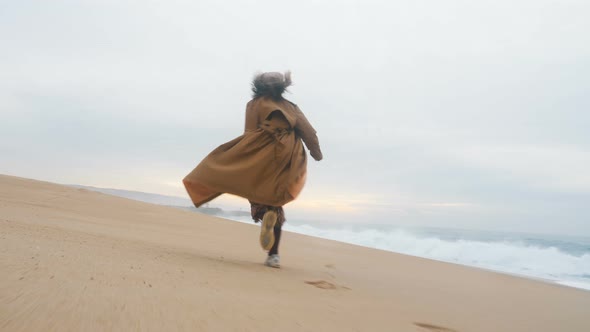 Active Girl Tourist Runs Along Sand Beach Against Oceanscape