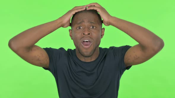 Disappointed Young African Man Reacting Loss on Green Background