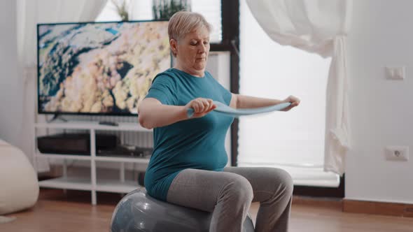 Senior Woman on Fitness Toning Ball Stretching Resistance Band