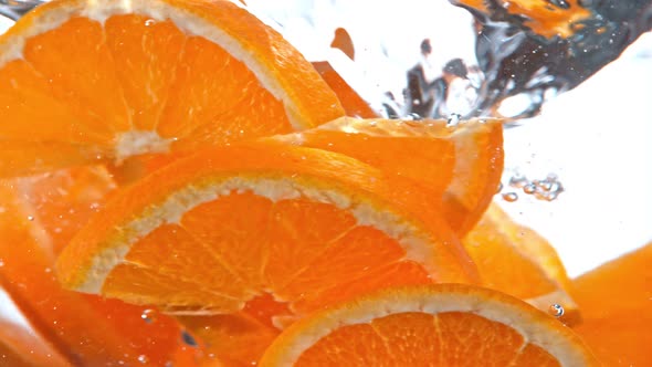 Super Slow Motion Shot of Fresh Orange Slices Falling Into Water Vortex at 1000 Fps alt