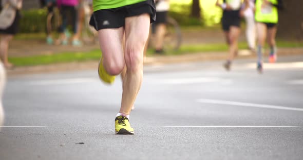 4K - Marathon athletes legs. front view