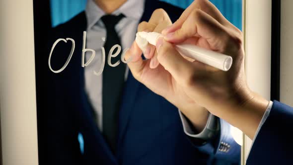 Smart Business Man Writing the Word Objective Mission on the Mirror Board