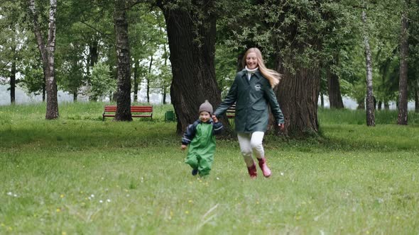 Funny Kid in Rain Boots Playing in a Rain Park