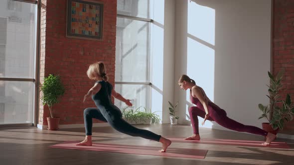 Young Women in Sport Uniform Does Complex of Asanas in Yoga Studio