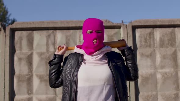 Young Woman in Pink Balaclava with Baseball Bat