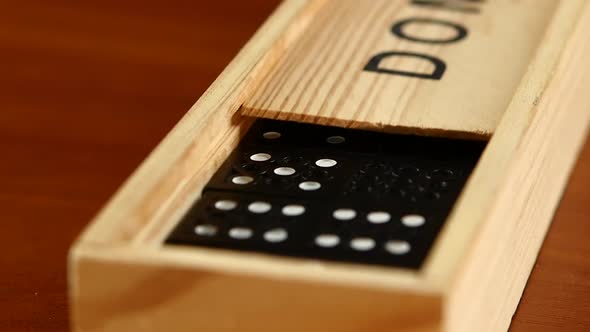 Domino Game in Closed Box, Isolated on Wooden Surface, Slow Motion