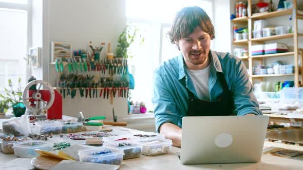 Smiling man typing on laptop