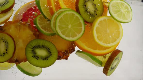 Slices of Different Fruits Fall Into the Water, Multifruit Juice, Slow Motion Close-up