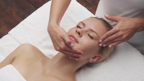 Young, healthy and beautiful woman gets massage therapy in the spa salon.