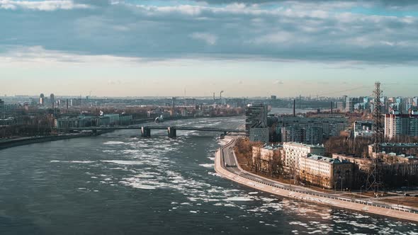 Wide River with Ice Drift Flowing Across City Timelapse