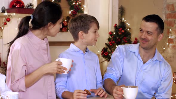 Family Is Drinking Tea with Homemade Cookies at Christmas Eve