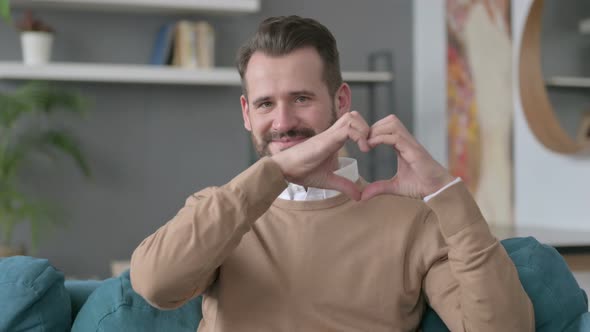 Portrait of Man Showing Heart Sign By Hand