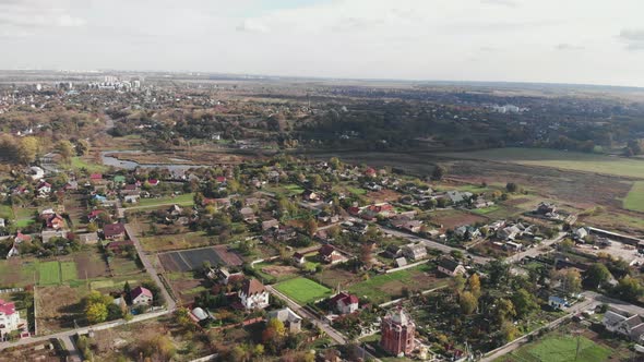 Aerial view of countryside with cloudy blue sky. Forest countryside with cottages and buildings