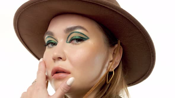 Woman in a Autumn Look in Studio in Green Parka and Hat Turns and Poses To the Camera