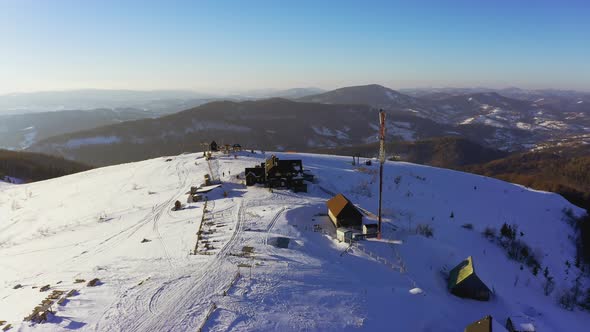Old Ski Station on a Snowy Mountain Slope with a Lot of People on Skis and Snowboards
