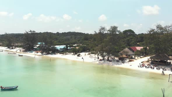 Paradisiac clear water full of fishing boats bathing the golden sand in Koh Rong Sanloem, Cambodia