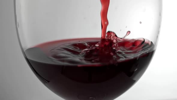 Slow Motion Shot of Red Wine Being Poured Into Glass