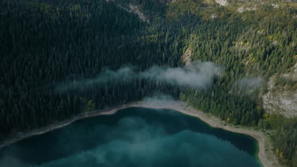 Flying above the autumn Black lake in Montenegro. Aerial view of National park Durmitor in fall