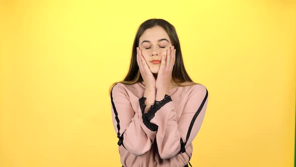 Young Beautiful Girl Posing Surprisingly on Yellow Background