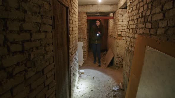 a Girl in a Terrible State Searches a Scary Basement to Find a Possible Shelter in Case of a Bomb