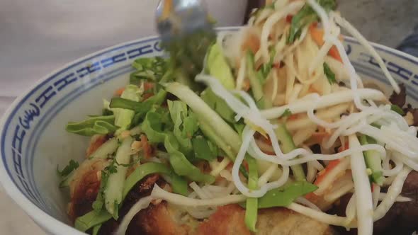 Mixing asian food bowl. Vegetables and fried meat with rice in a bowl.