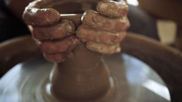 a Potter on a Potter's Wheel Makes a Tall Narrow Vase Out of a Wide Bowl