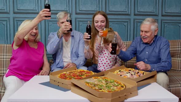 Multigenerational Family Having Lunch Party Eating Pizza Food Laughing Raising Toast at Home