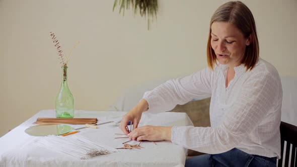 Mature Woman Making Paper Vine Basket at Home