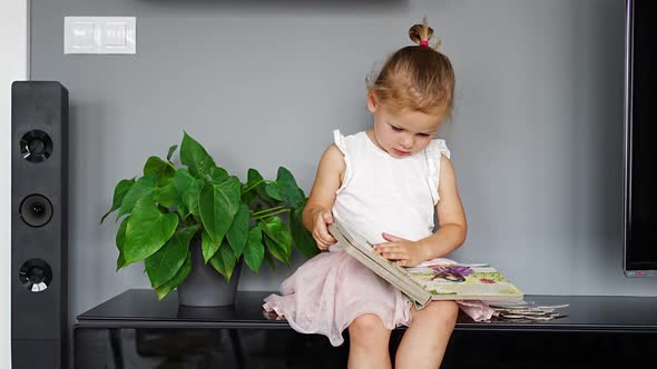 Adorable Toddler Little Girl Reading Book at Home