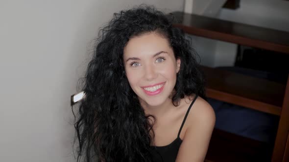 Smiling Woman Sits at Stairs