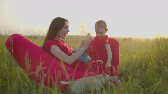 Playful Mom Tickling Laughing Baby Girl Outdoors