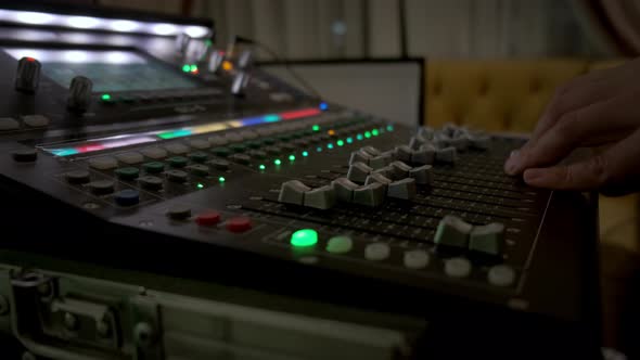 Close Up of Hand Sound Producer Using a Music Mixer with Editing Tools in Concert