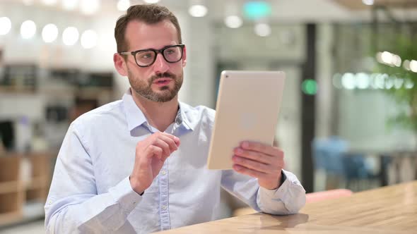 Businessman Doing Video Call on Tablet in Office 