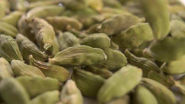 Dried cardamom seeds fall in a heap in slow motion
